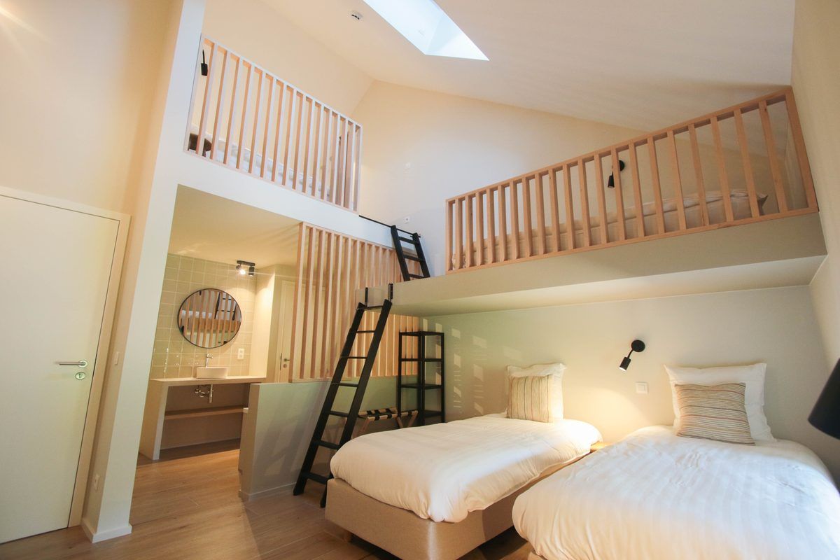 Chambre familiale : lits au sol et mezzanine accessible par une échelle