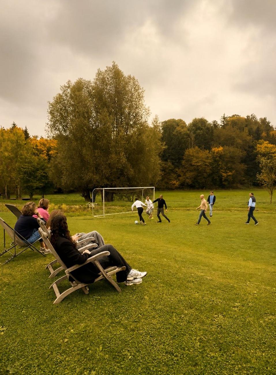 Partie de football sur le terrain du domaine, spectateurs en transats