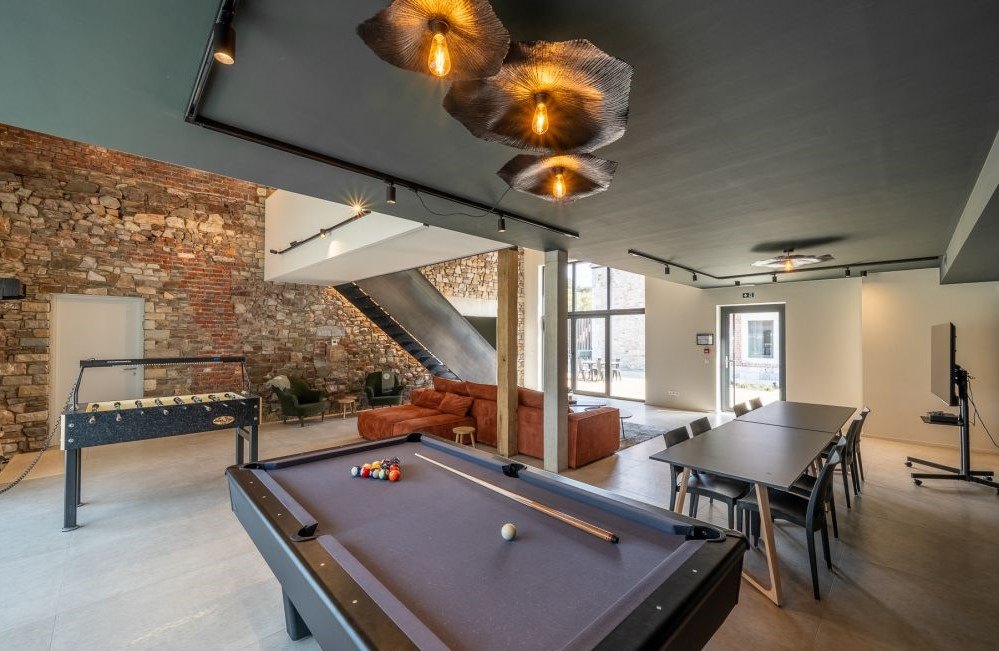 Coin détente du Moulin : billard et fauteuils sous les suspensions