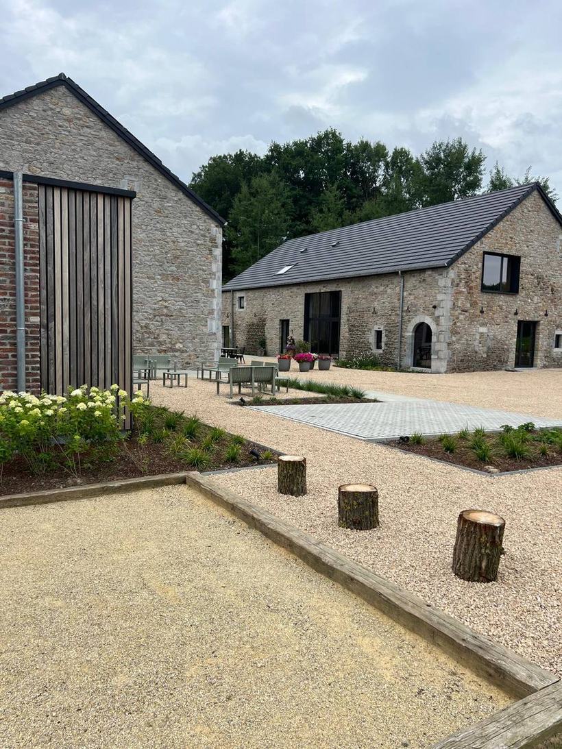 Une main tenant une boule de pétanque au-dessus du terrain